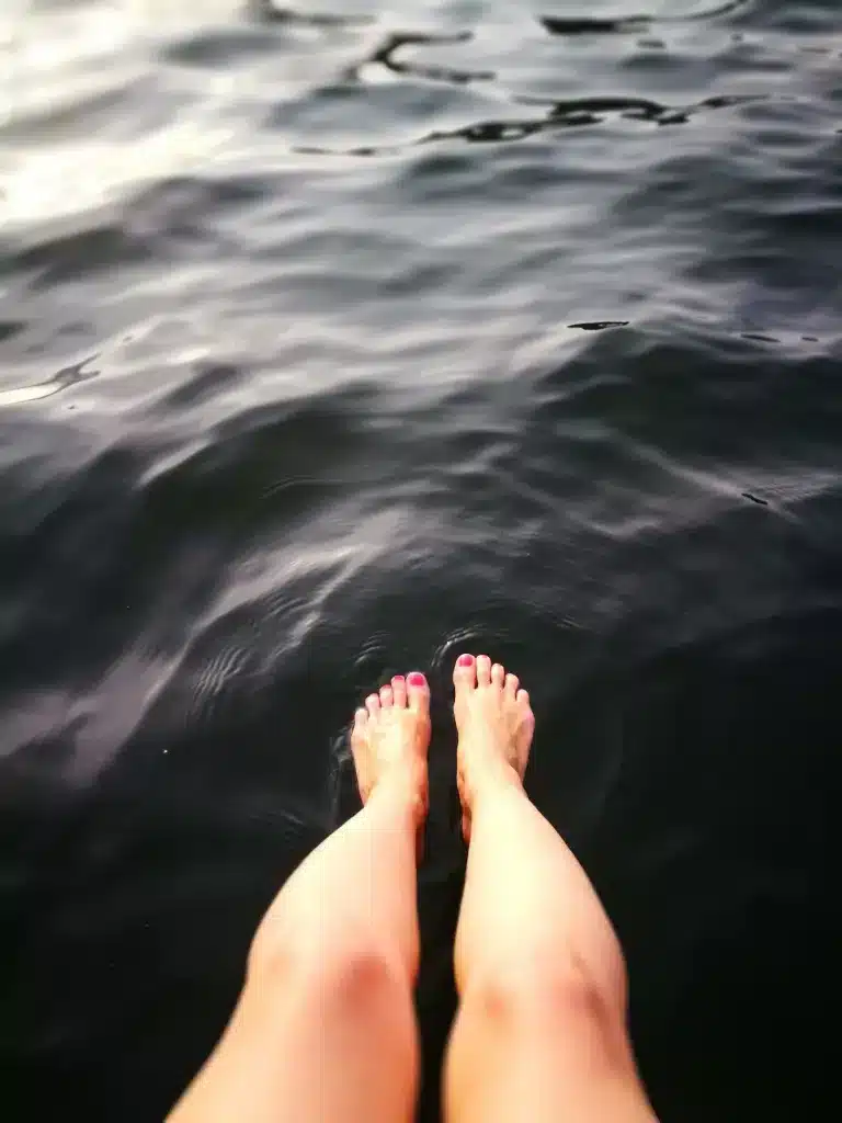 woman dabbling her feet in sea water