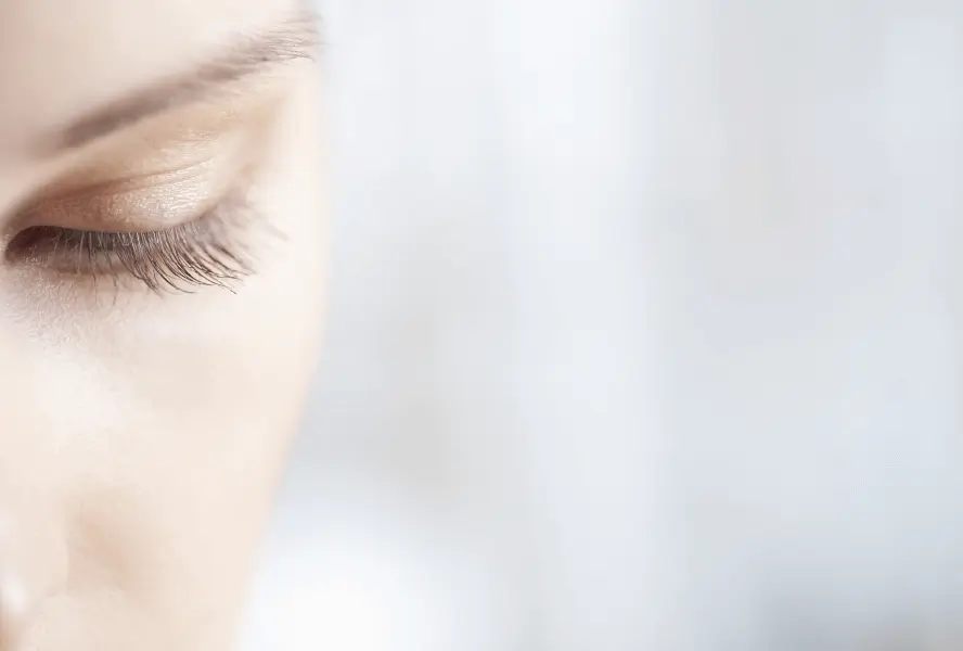 a woman's half face focussing on her eye and eyelashes