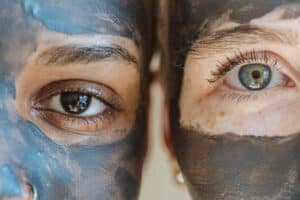 two ladies with clay face masks one blue clay mask and one grey natural clay mask