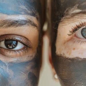 two ladies with clay face masks one blue clay mask and one grey natural clay mask